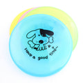 Lifestyle shot of a happy dog resting with its FurryFable interactive flying disc after an active play session