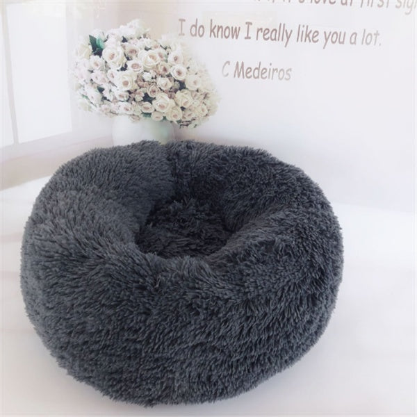 A small dog peeking out from the cozy interior of a FurryFable pet bed